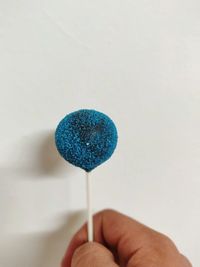 Close-up of hand holding blue umbrella
