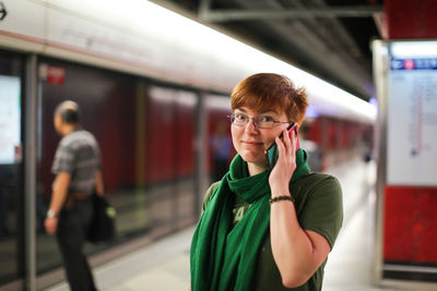 Portrait of woman standing on railroad station