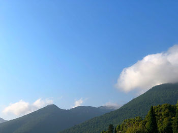 Scenic view of mountains against blue sky