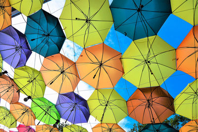 Low angle view of colorful umbrellas hanging against sky