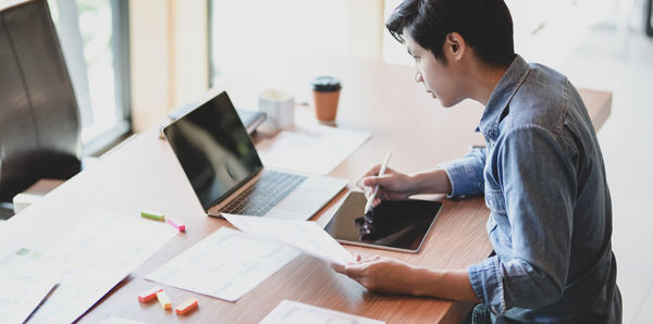 Businessman using digital tablet on desk in office