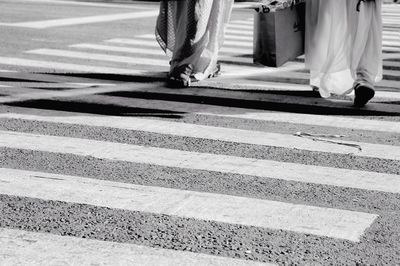 Low section of women walking on road