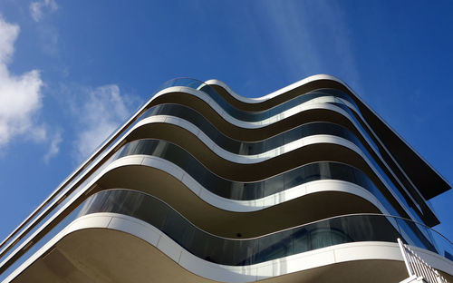 Low angle view of modern building against blue sky