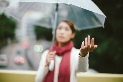 Young woman with umbrella in rain