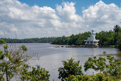 Scenic view of river against cloudy sky