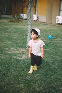 Rear view of boy playing with ball in park