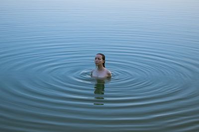 High angle view of young woman swimming in lake