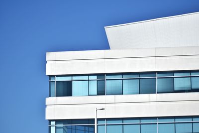 Low angle view of modern building against clear blue sky