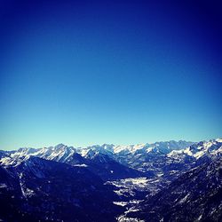 Scenic view of snow covered mountains against clear sky