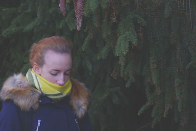 Close-up of young woman against trees