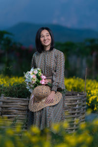 Portrait of a smiling young woman standing against wall