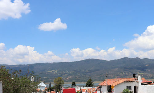 Houses and buildings in town against sky