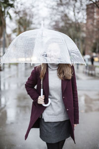 Woman with umbrella walking in city