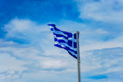 Low angle view of flag against blue sky