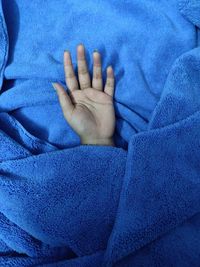 Close-up of baby hand on bed