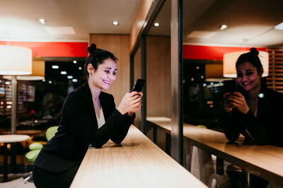 Young woman smiling while standing on table