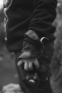 Midsection of man holding camera