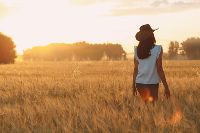 Rear view of woman standing on field