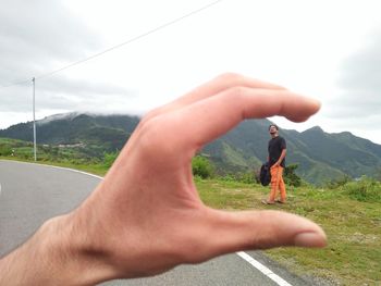 Midsection of man against mountain range against sky