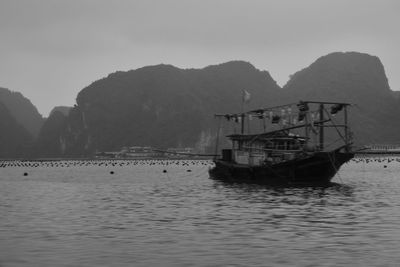 Fishing boat in sea against sky