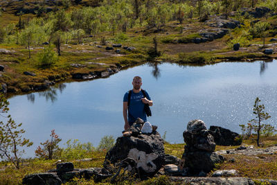 Man sitting on rock by lake