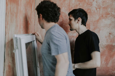 Caucasian men wash window frames.