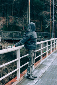 Man standing on railing in winter