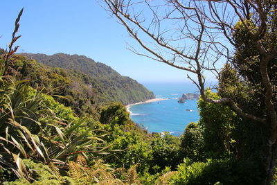 Scenic view of sea and mountains against clear sky