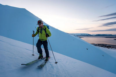 Man backcountry skiing in iceland at sunrise