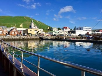 Houses by buildings in town against sky