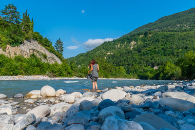 Full length of man standing on rock against sky