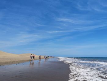 People on beach against sky