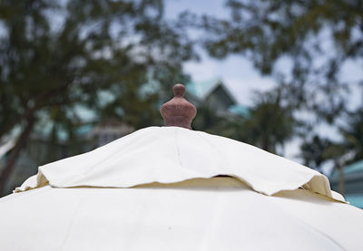 Low angle view of cross on roof of building against sky