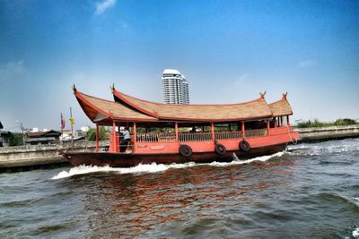 Stilt houses by sea against clear sky