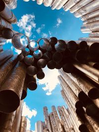 Low angle view of pipes against blue sky