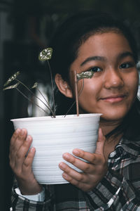 Portrait of a smiling young woman holding drink