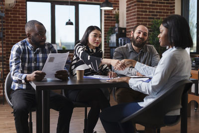 Friends using laptop while sitting at restaurant