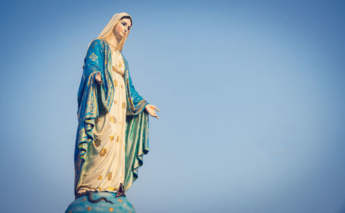 Low angle view of statue against blue sky