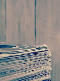 Stack of old vinyl records in sleeves with textured wood background