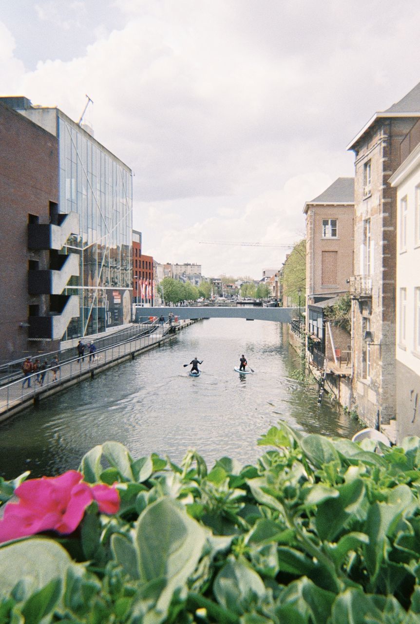 RIVER AMIDST BUILDINGS AGAINST SKY