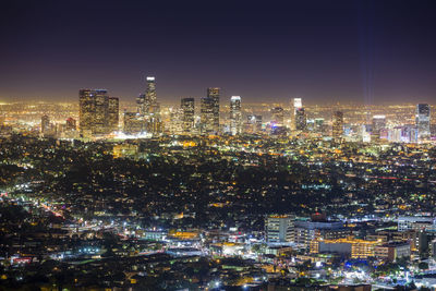 Illuminated cityscape against sky at night