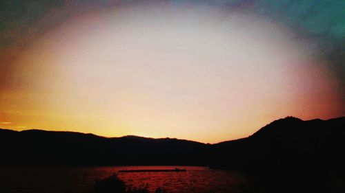 Scenic view of silhouette mountains against clear sky during sunset