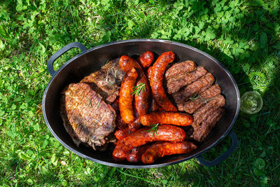 Roasted barbeque in a dish - sausages, steaks, kebabs and chicken meat with rosemary