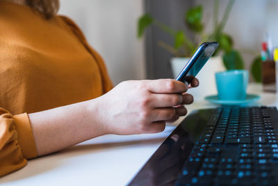 Midsection of woman using mobile phone