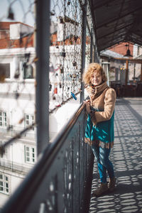 Woman standing by railing