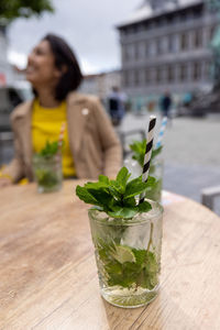 Young woman holding drink on table