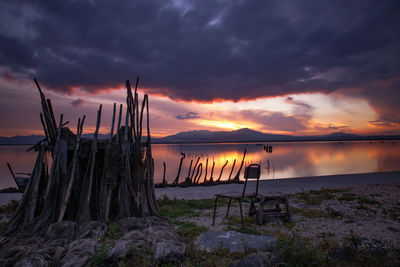 Scenic view of sea against dramatic sky during sunset