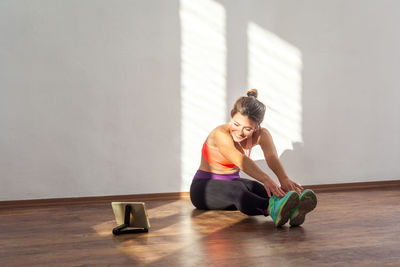 Woman looking away while sitting on floor at home