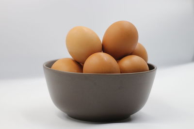 Close-up of eggs in bowl against white background