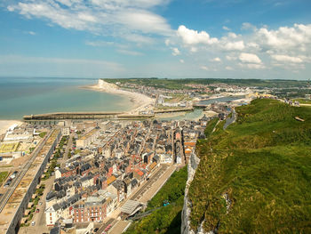 High angle view of city by sea against sky